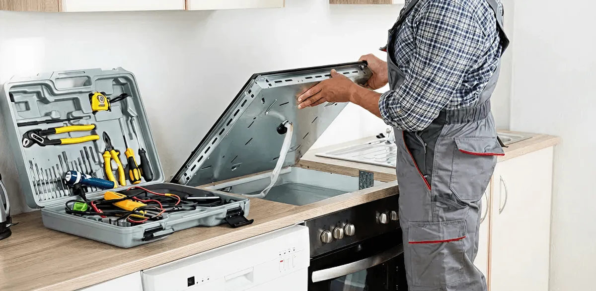 Handyman repairing a cooktop and checking wiring connections in Colorado Springs, CO