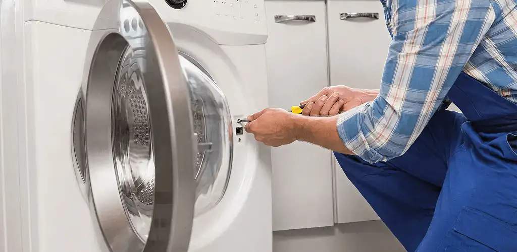 Handyman repairing a clothes dryer and checking electrical connections in Colorado Springs, CO