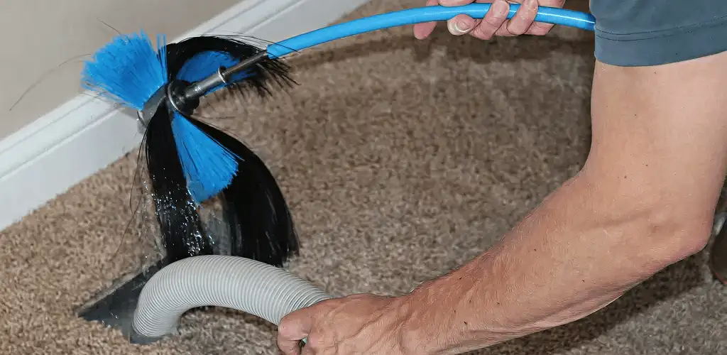 Dryer vent cleaning technician brushing lint from a vent line in Colorado Springs, CO