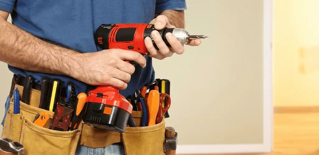 Handyman holding a power drill for home repairs and installations in Colorado Springs, CO
