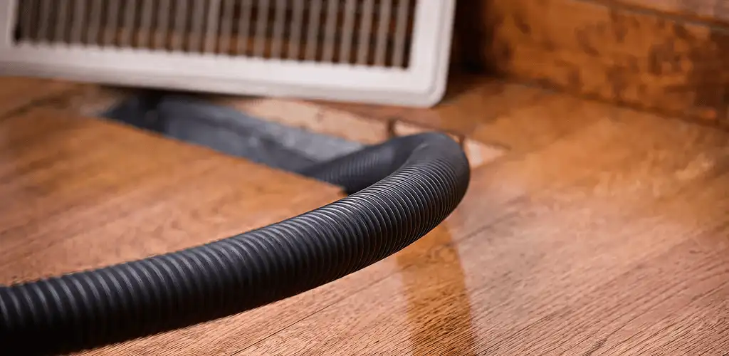 Air duct cleaning hose inserted into a floor vent for ductwork cleaning in Colorado Springs, CO
